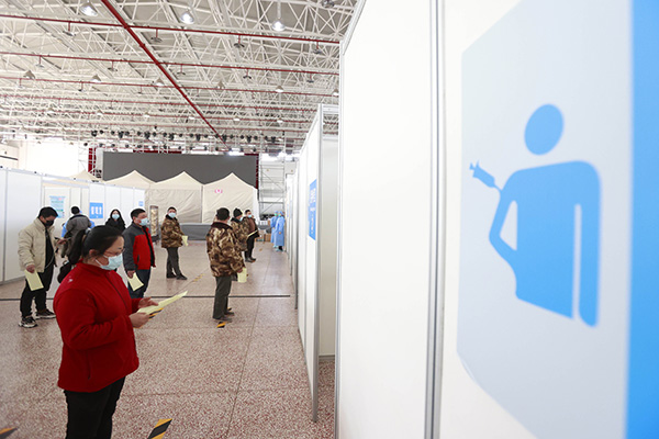 2021年3月2日，接种室前严格执行“一米线”防疫措施。当日，部分北京延庆冬奥赛区的工程建设者来到八达岭国际会展中心接种新冠疫苗。中新社记者 韩海丹 摄
