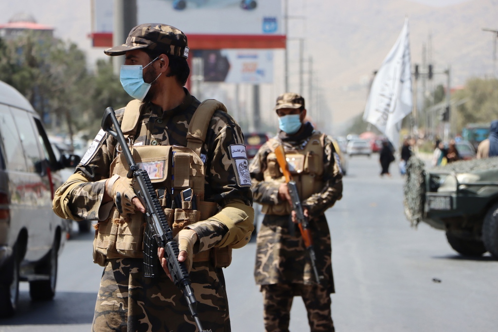 塔利班成员携武器在喀布尔巡逻。