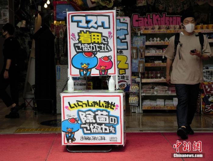 资料图：日本东京某商店在入口处以漫画形式提醒顾客采取戴口罩和除菌等防疫措施。 中新社记者 吕少威 摄